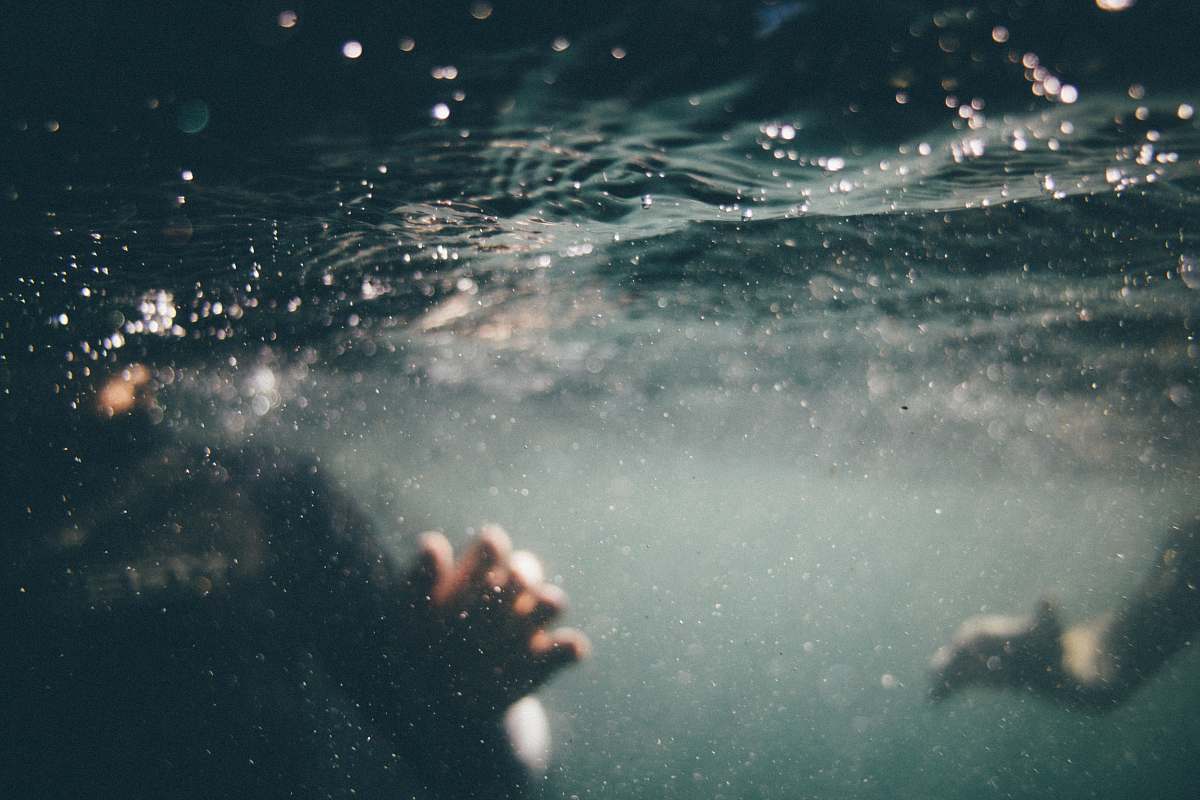 water underwater photo of person wearing black shirt grey